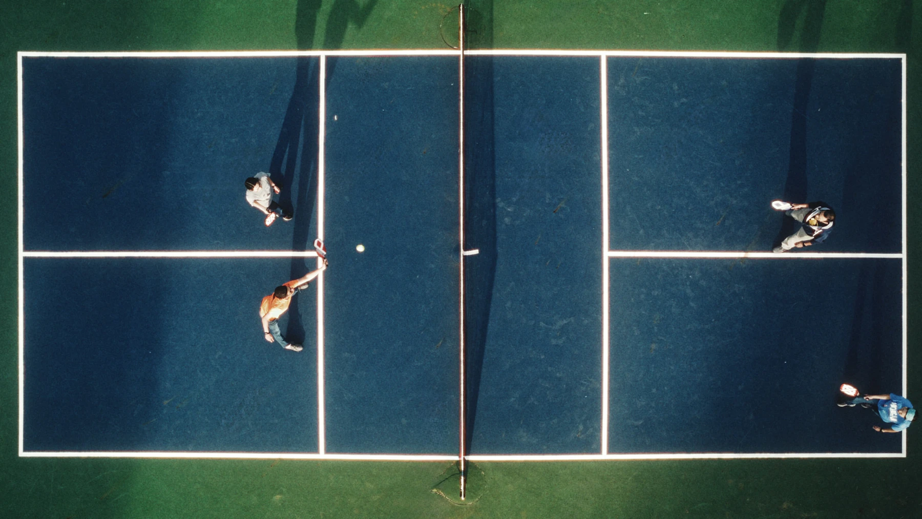 Vista aérea de cuatro jugadores disputando un partido de pickleball
